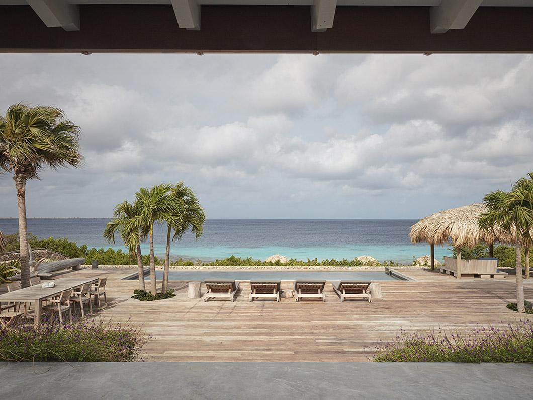 View at sea and GIJS daybeds / sunloungers from bedroom at beach villa on Bonaire