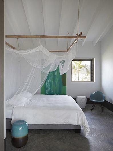 Bedroom with bed and mosquito net at beach villa on Bonaire