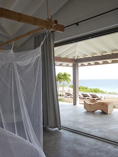 View at sea and GIJS daybeds / sunloungers from bedroom at beach villa on Bonaire